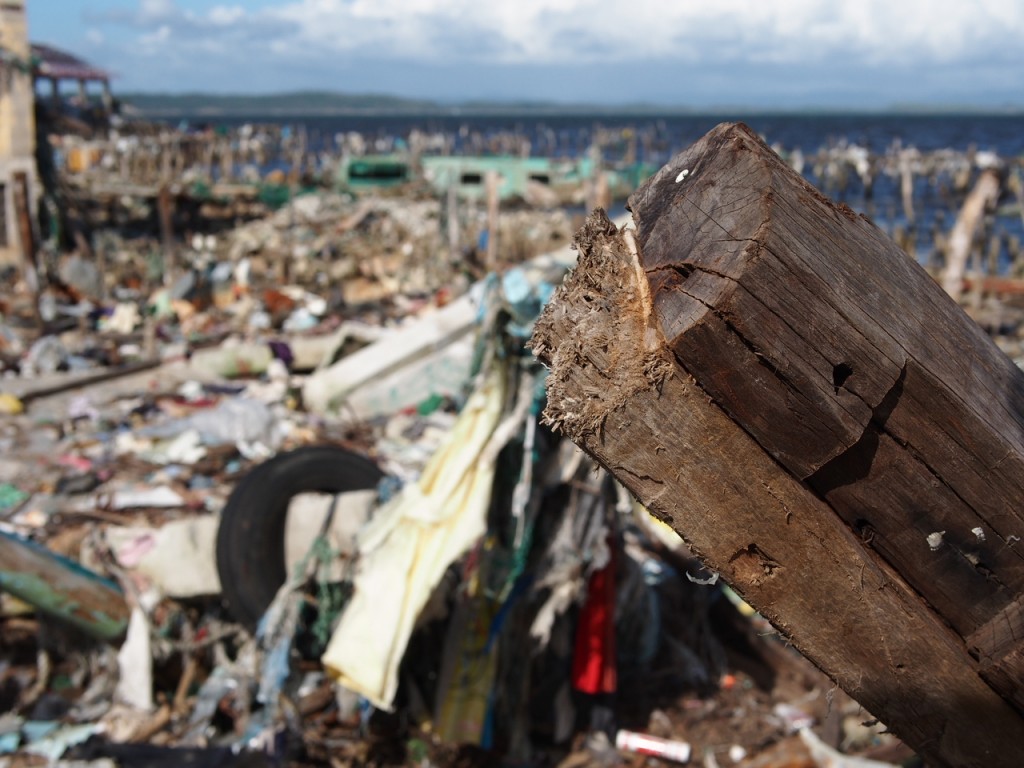 Two wooden beams in front of a field of destruction left by super typhoon Yolanda