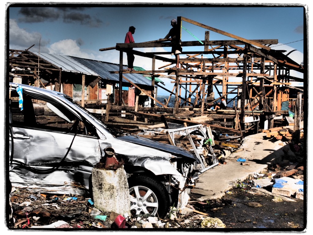 Some men work on rebuilding a wood frame house after super typhoon Yolanda