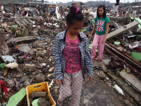 Day Seventeen – Super Typhoon Yolanda Two teenage girls help clear the rubble from their destroyed home